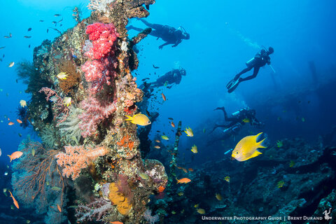 Divers explore the USAT Liberty Wreck in Tulamben, Bali. Sony a6300, Tokina 10-17mm with Metabones, manual focus. Lit with one YS-D1 strobe and one I-Torch Venom38 video light. Photo: Brent Durand