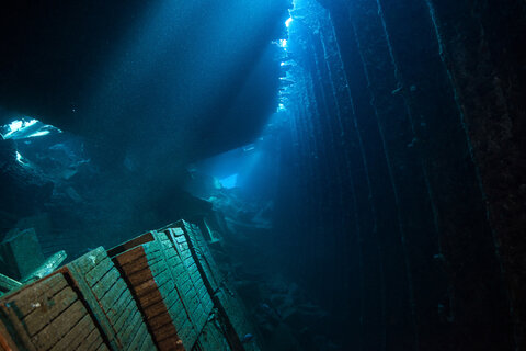 Shafts of light illuminate the cargo of tile in the hold of the Tile Wreck, Red Sea.