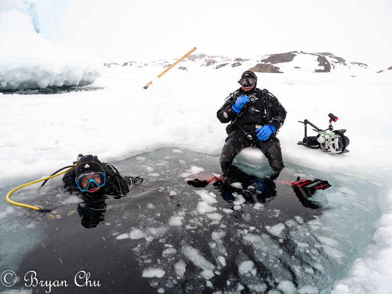 Me looking very happy in the icehole, about to start a dive. Olympus OM-D E-M1 Mark II, 12-100mm F4.0 lens.