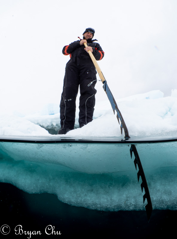Sven using the ice saw to trim the icehole to keep it safe. Was also the main tool used to cut the icehole. Olympus OM-D E-M1, Olympus 8mm F1.8 fisheye lens, Nauticam housing. F/18, 1/100 s, ISO 250.