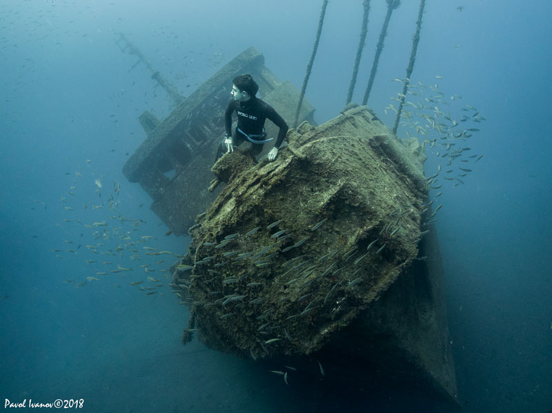 Freediver posing in front of wreck. Olympus TG-5, Olympus housing, Olympus PTWC-01 wet wide angle lens, ambient light. 4.5 mm focal length, ISO 100, 1/60 sec, f/2.8.