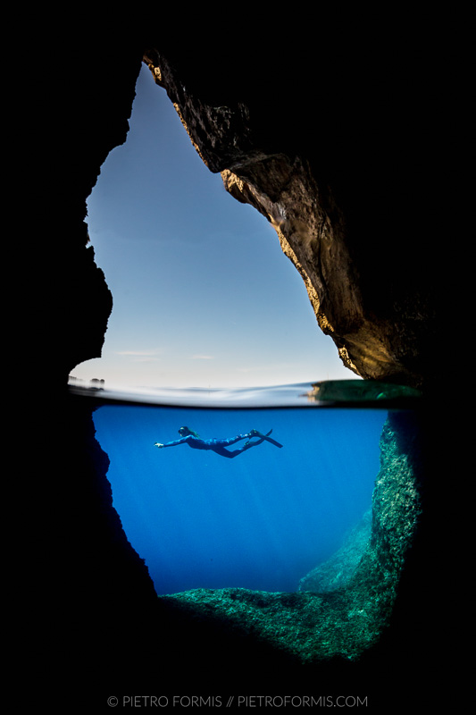 Diver in a semi-submerged cave. Model: Mari Lasco. Alghero, Sardinia. Shot with Canon 5D Mark III. 1/500 sec, f/14, ISO 800 Tokina 10-17, 8”Nauticam dome